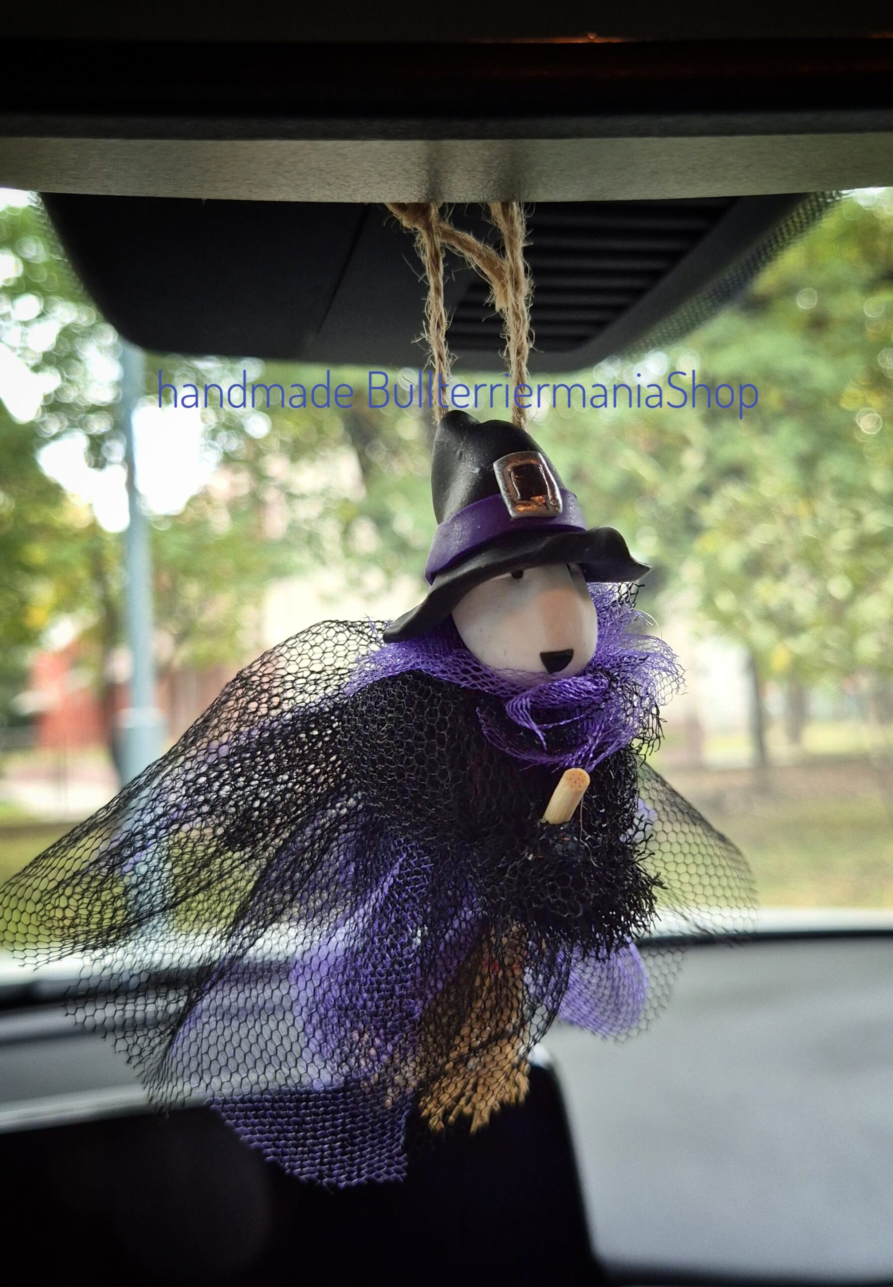 andmade Witch Bull Terrier Halloween ornament hanging from a car mirror