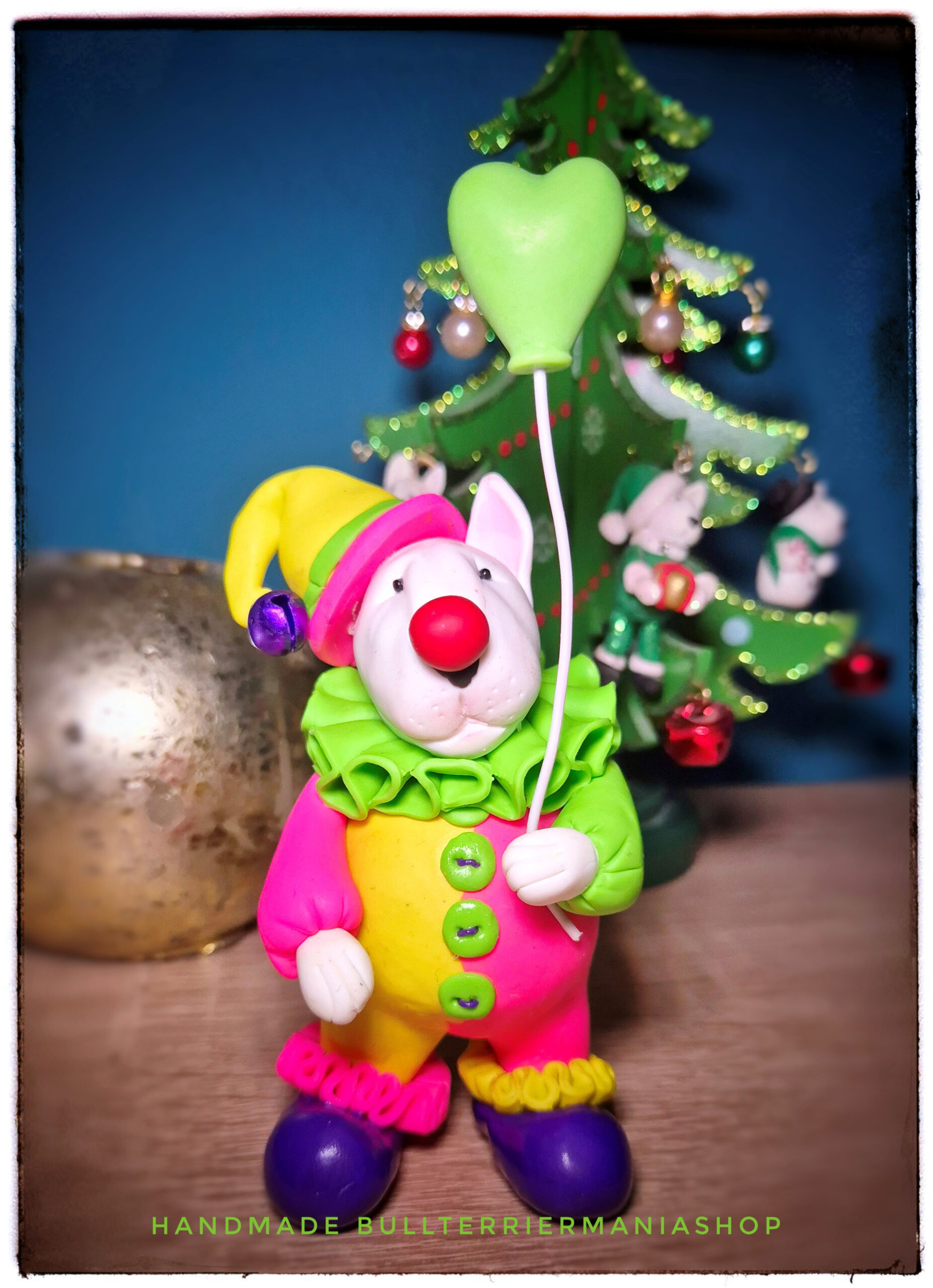 Colorful handmade Bull Terrier clown figurine with a heart balloon.