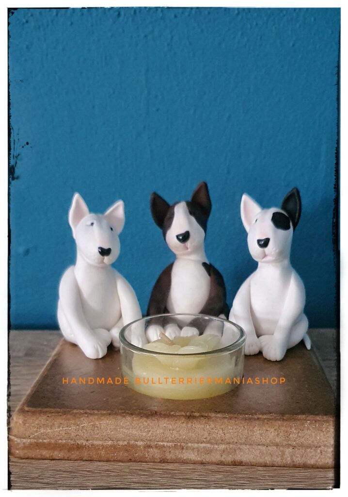Bull Terrier candle holder with three Bull Terrier figurines around a tea light.