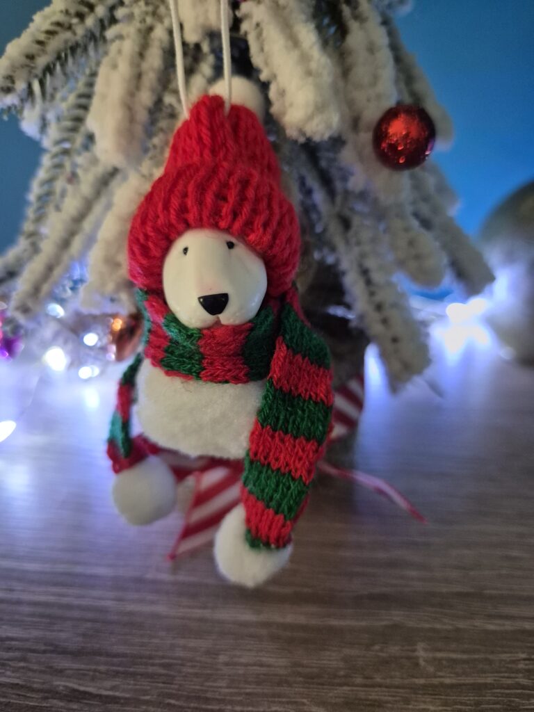 Bull Terrier Pom Pom Christmas ornament hanging on snowy Christmas tree